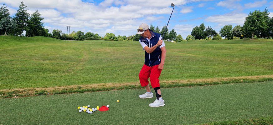 Stickan står på en grön golfbana och svingar en klubba. Fotograf: Åsa Lundborg.