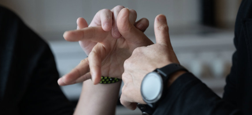 Närbild på två händer som kommunicerar med taktilt teckenspråk.