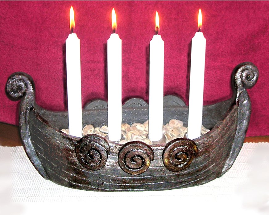 Adventsljusstake i form av ett vikingaskepp med fyra vita ljus.