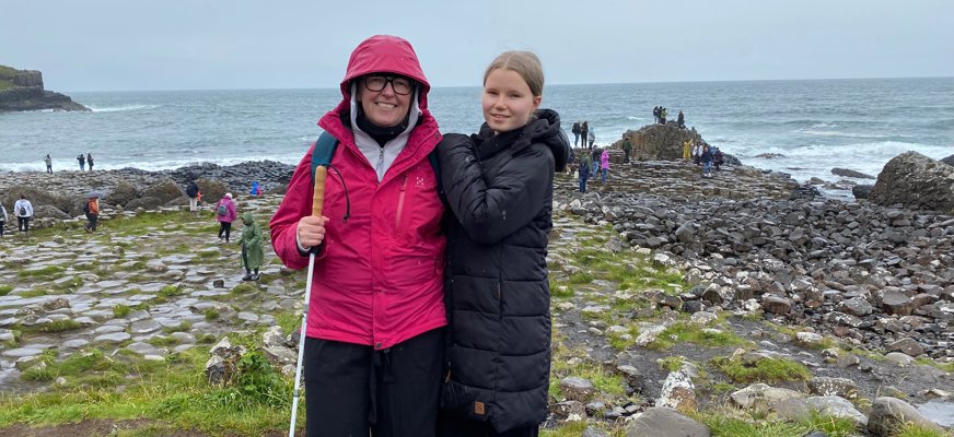 Åsa Gunnarsdotter står tätt intill sin dotter Smilla och de ler båda mot kameran. I bakgrunden syns ett irländskt berglandskap.