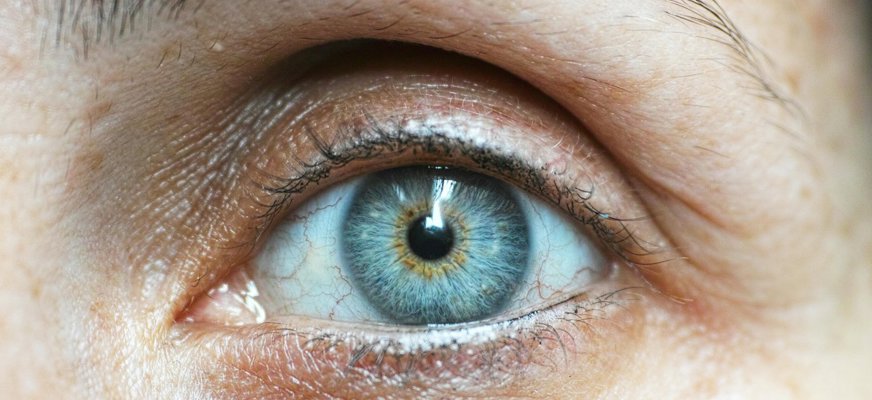 Närbild på ett öga med blågrön ögonfärg.