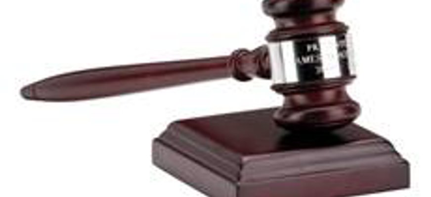 En mörkbrun ordförande klubba på ett mörkbrunt träb