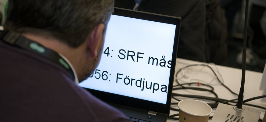 En person sedd snett bakifrån som granskar en text på en skärm med förstoringsverktyg.