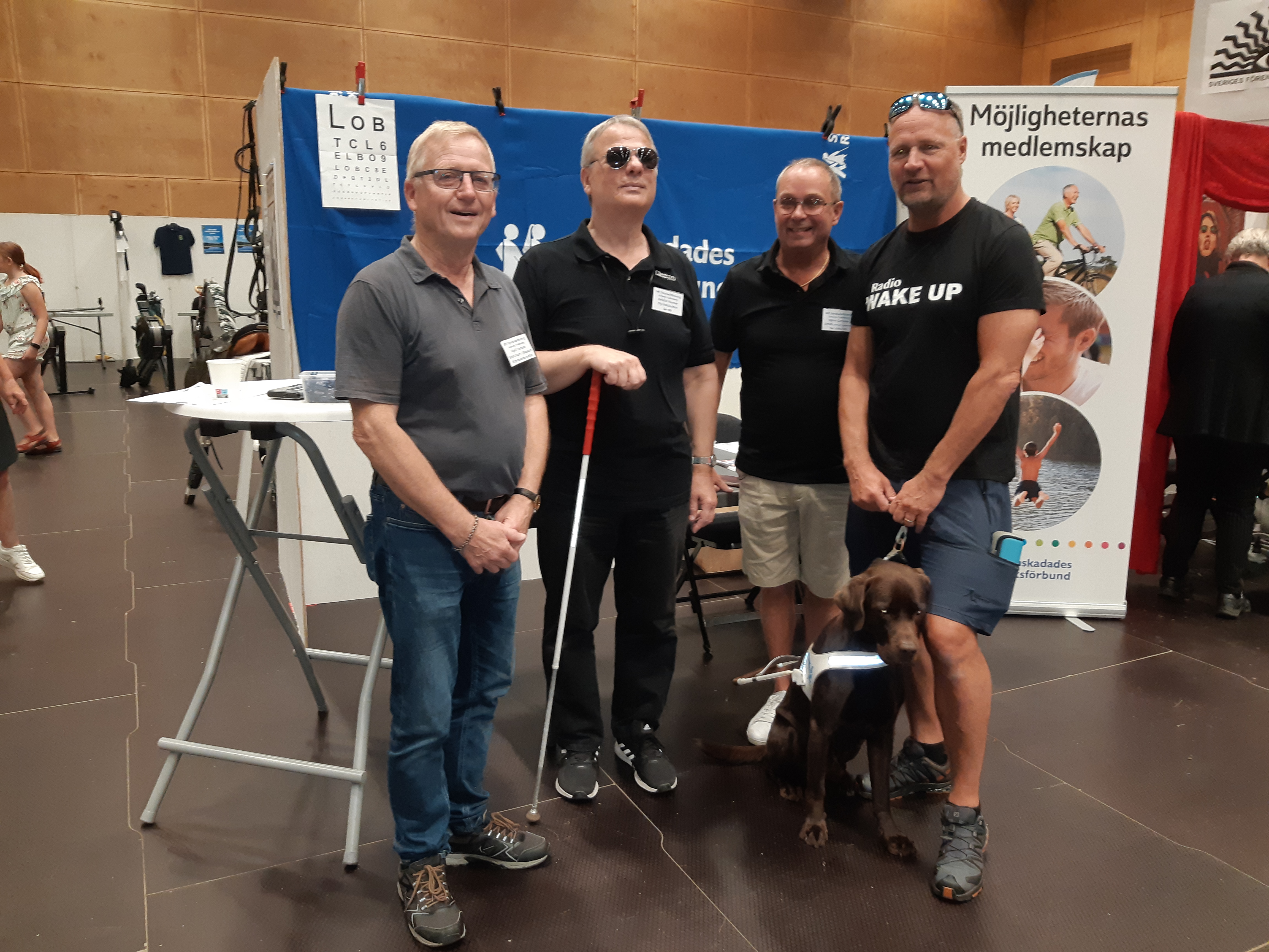 4 män med mörka tröjor framför utställningsmonter.