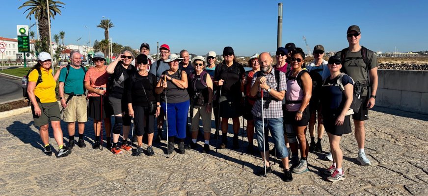 En gruppbild på alla 20 deltagare. De tittar in i kameran och har på sig ryggsäckar, kepsar, fotriktiga skor och solglasögon. I bakgrunden syns palmer och en blå himmel.