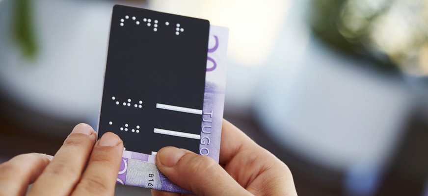 Person som använder sedelmått med punktskrift