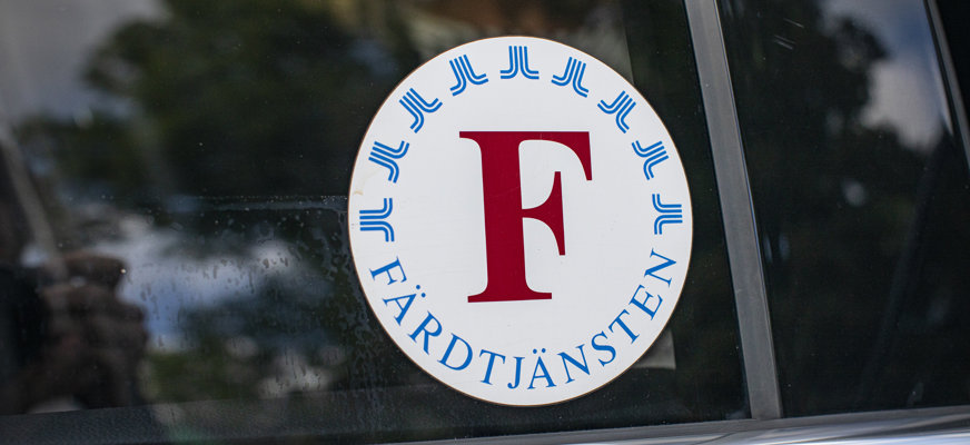Ett klistermärke med Färdtjänstens logotyp som sitter på en bilruta.