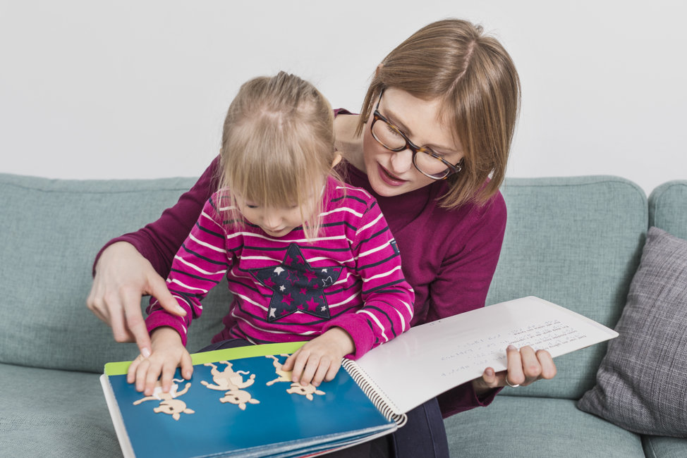 Vuxen och barn läser taktil bilderbok