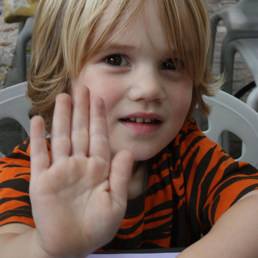 Barn i 4-årsåldern signalerar stopp med handflatan mot kameran.