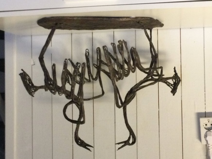 Skulpturen är en abstrakt representation av två fågelskelett i en slags dialog eller konfrontation. De tvinnade metallformerna skapar en känsla av rörelse och spänning, där de båda kropparna verkar sväva mot varandra med utsträckta ben och vingar. Denna komposition kan symbolisera möten, motsättningar eller balans mellan två krafter. Genom att använda råa material och skelettliknande former väcker konstverket tankar om livets skörhet, naturens struktur och kanske även dödens estetik. Ett samtal i metall mellan två fåglar, frusna i ett evigt ögonblick.